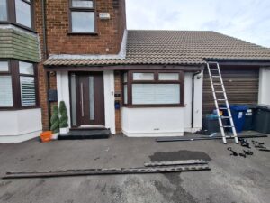 Front view of Penwortham house with front gutter removed ready for new gutter lying on floor to be attached.