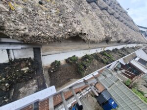 View down top of blocked and overgrown guttering in Hoghton.