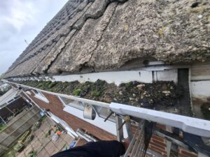 Wide angle view of upper gutter running along back of terraced properties in Hoghton.